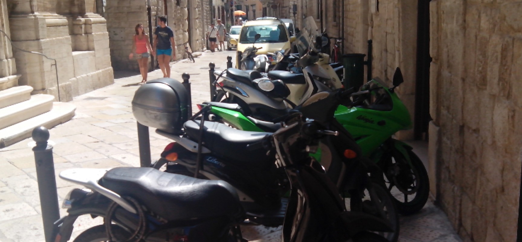 Su via Giulio Frisari (Biblioteca Comunale) l’area pedonale diventa parcheggio di motocicli / FOTO